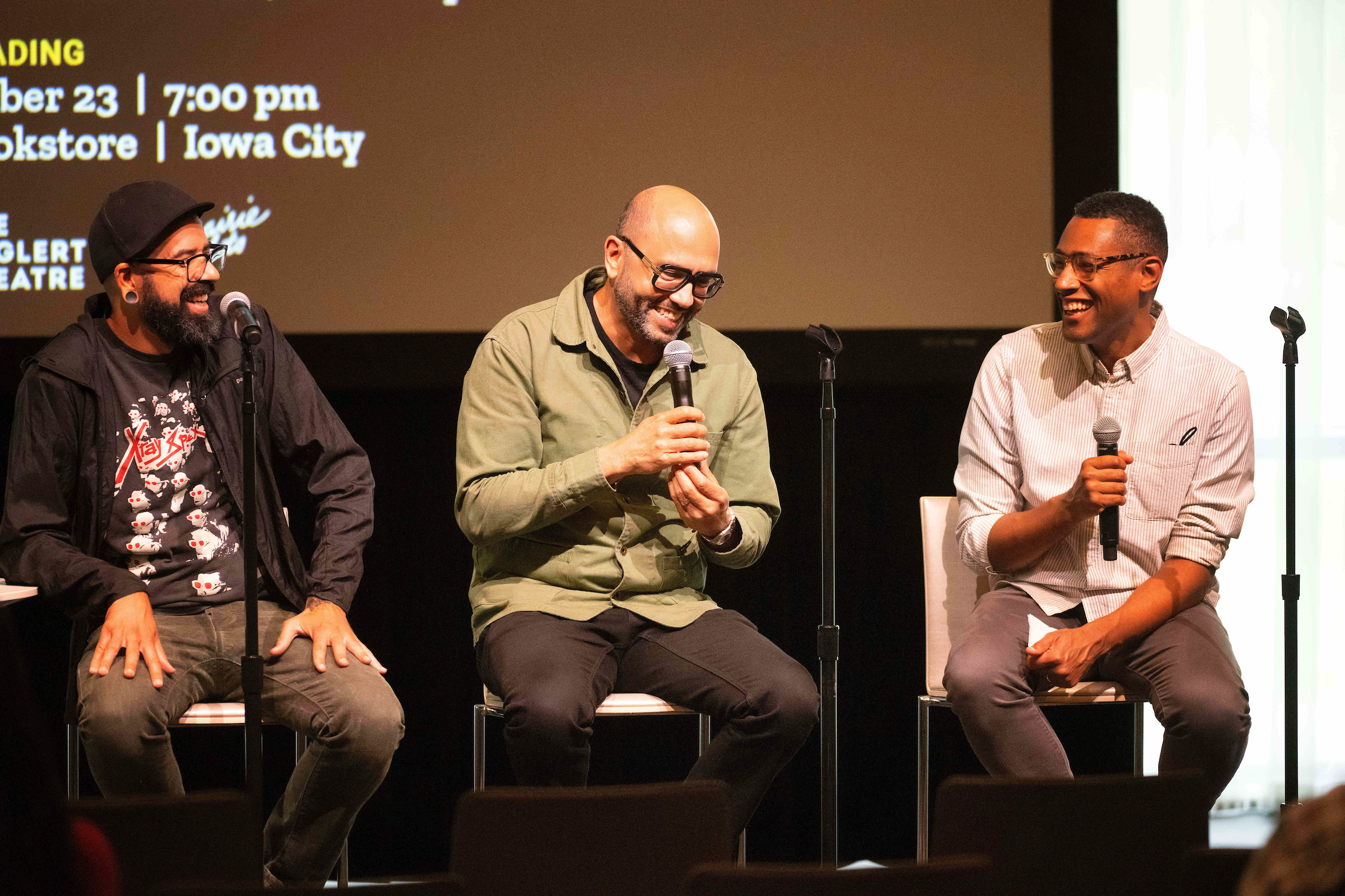 three authors on stage laughing