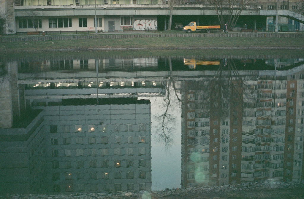 Reflection of industrial buildings in a pond.